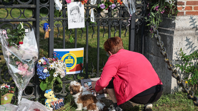 A woman lays flowers as villagers and fans pay tribute to late French actor Alain Delon, in front of his property in Douchy, France, 19 August 2024